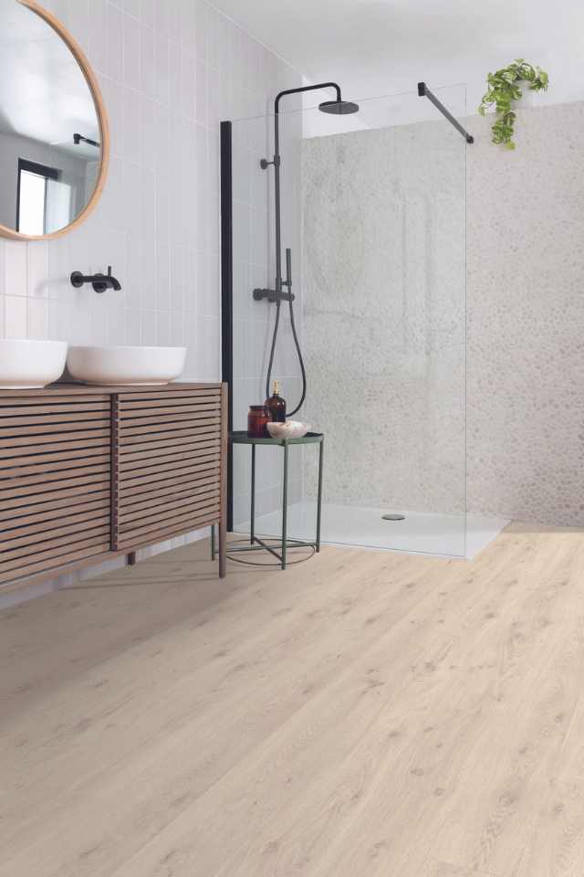 white oak look laminate flooring in modern white bathroom with glass shower